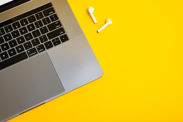 Top view on a smartphone laptop keyboard and wireless headphones