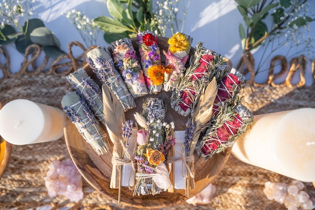 Top view of smudging sticks with dried flowers on a wooden tray