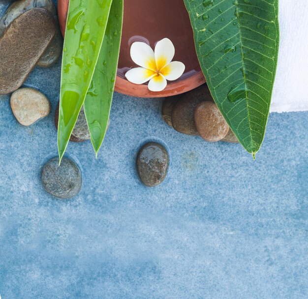 Top view of spa objects with white towel for massage therapy on blue background