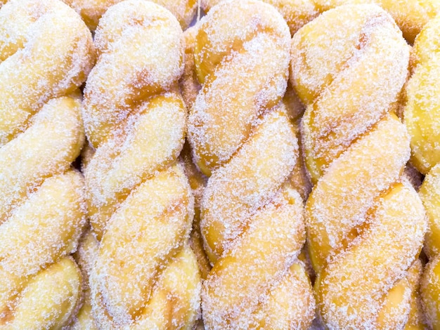 Top view of spiral sugars doughnuts on shelves in the bakery shop