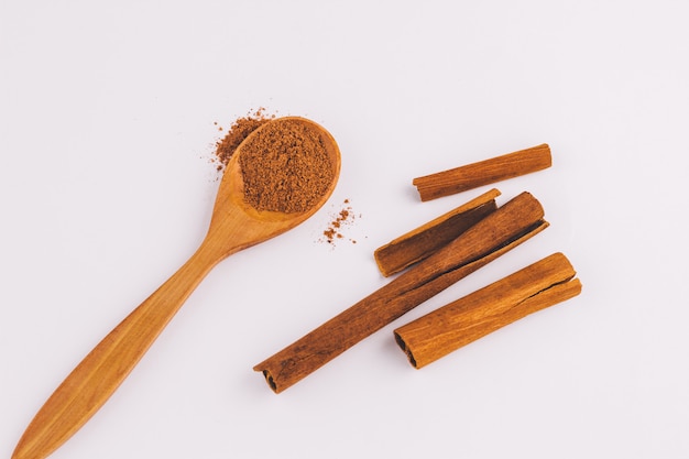 Top view of a spoon of sandal wood with cinnamon  on light  background