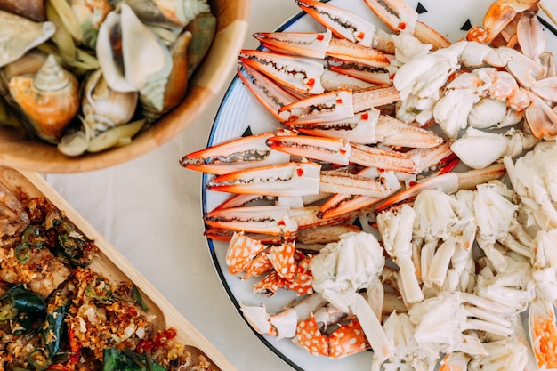 Top view of steamed Flower Crabs and Giant Mud Crabs with separated parts of steamed crab.