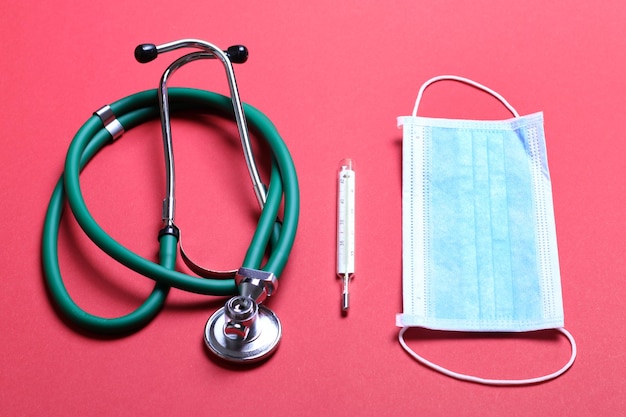 Top view of stethoscope medical protective mask and thermometer on colorful background Medical accessories concept