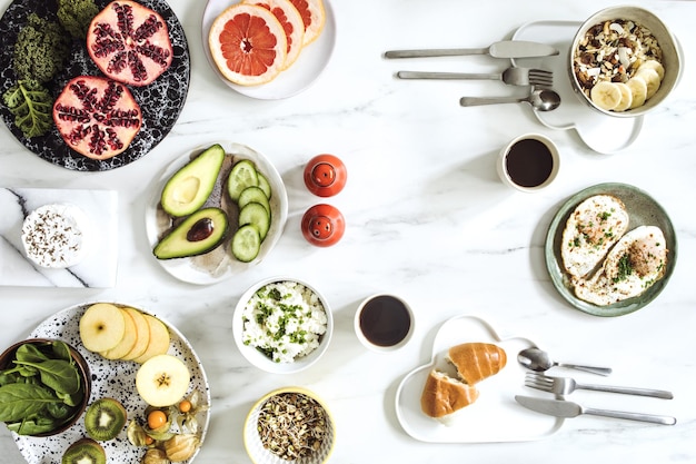 The top view of super food on the white marble table Flat lay Variuos vegetables ingredients and healthy food for vegetarians Breakfast table