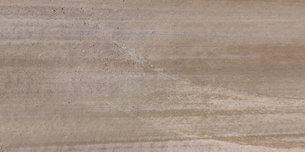 Top view of surface of gravel road made of small stones and sand with traces of car tires