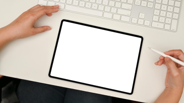 Top view Tablet mockup on modern white office desk A female using tablet at her desk