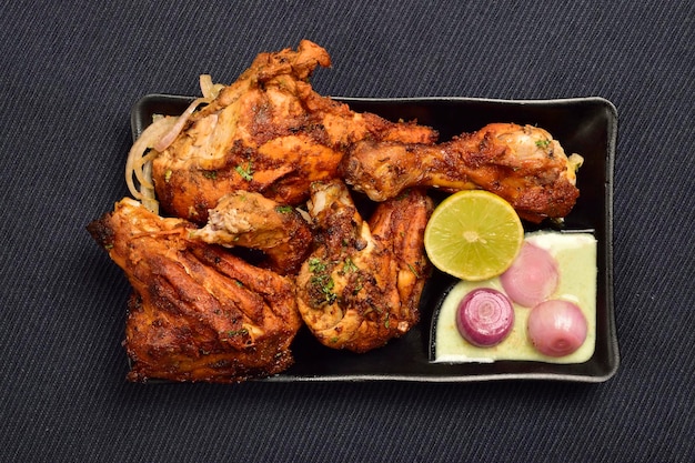 Top view of tandoori chicken served with online chutney in plate