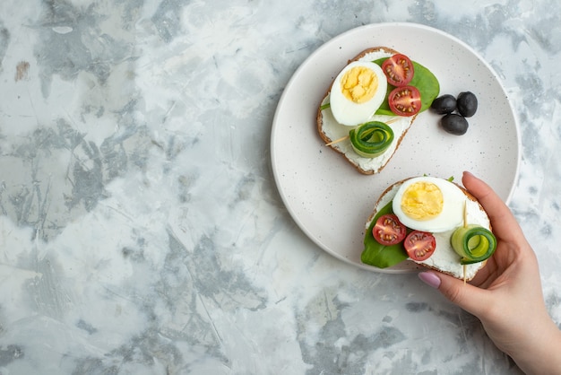 top view tasty egg sandwiches with tomatoes and olives inside plate white surface background lunch sandwich food meal bread health diet