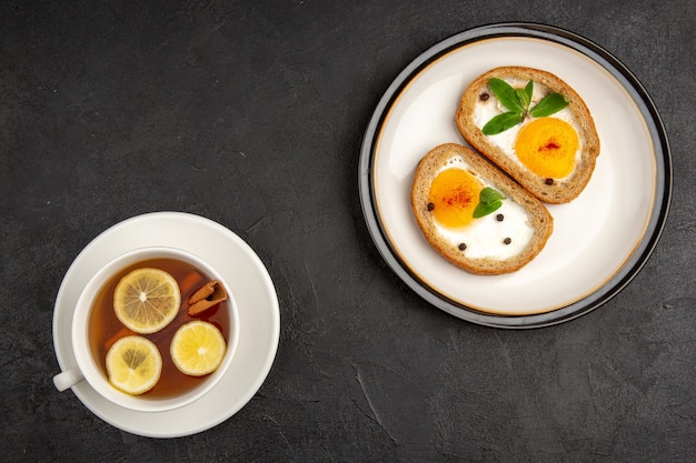 top view tasty egg toasts with cup of tea on dark background meal bread omelette food lunch morning breakfast tea