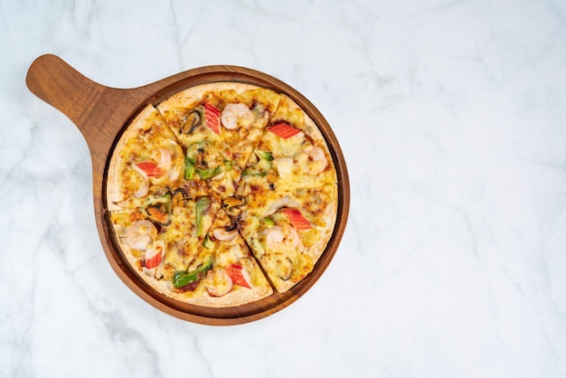 Top view of tasty hot baked seafood crispy pizza mussels shrimps and kani with chili pepper.