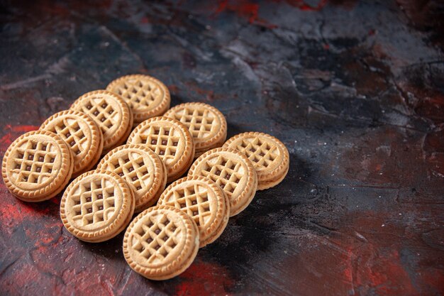 Top view of tasty sugar cookies laid side by side in three rows on the right side on mix colors background with free space