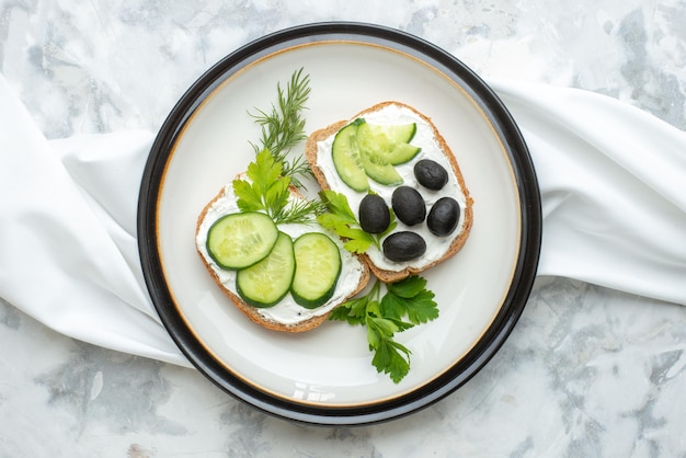 Top view tasty vegetable sandwiches with olives inside plate on white surface food meal diet horizontal dinner health