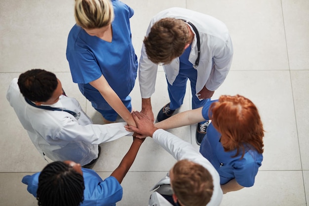 Photo top view teamwork or hands of doctors in stack with mission in collaboration for healthcare support hospital clinic people or group of medical nurses with solidarity motivation or community help