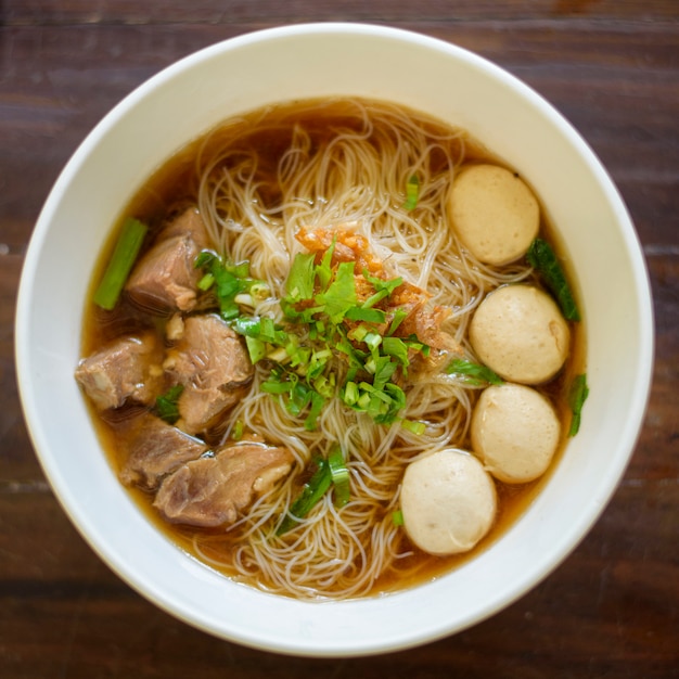 Top view of Thai food Noodle in bowl on wooden table