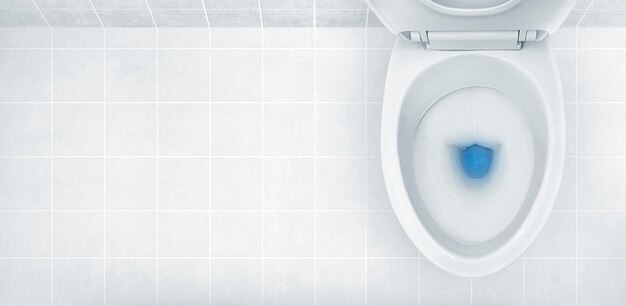 Photo top view of toilet bowl blue detergent flushing in it