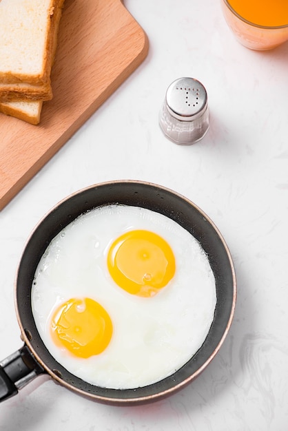 Photo top view of traditional healthy easy quick breakfast meal made of fried eggs served on a frying pan.