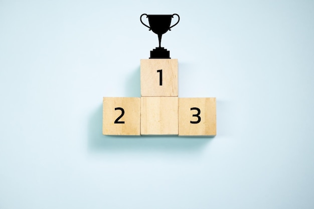 Top view trophy on top of wooden blocks set to podium Concept for success and teamwork