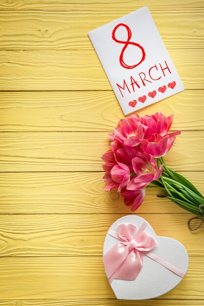 Photo top view of tulips on wood table. woman's day. 8 march. spring holiday concept