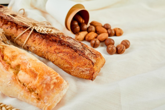 Top view of two baguettebread and nuts on a textile surface