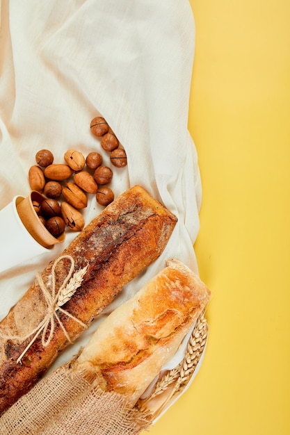 Top view of two baguettebread and nuts on a textile surface