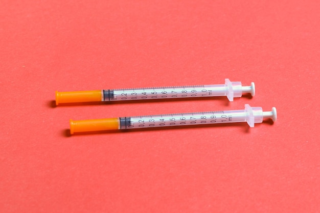 Top view of two insulin syringe at colorful background High level of glucose concept