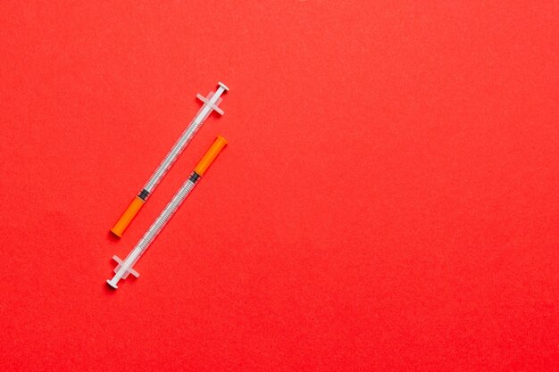 Top view of two insulin syringe at colorful background with copy space. High level of glucose concept.