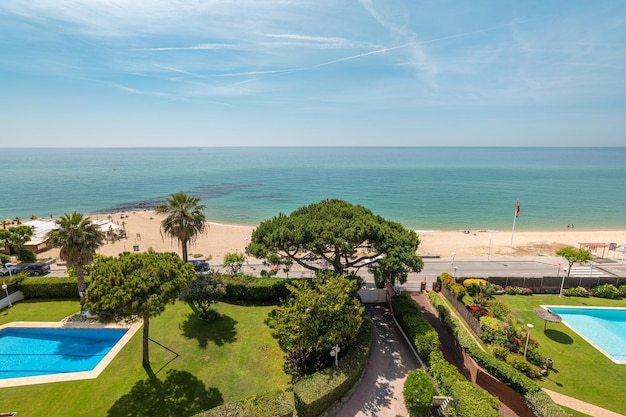 Top view of two swimming pools overlooking the coast and the sea on a sunny warm summer day while