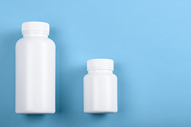 Top view two white plastic bottles on blue background for brand