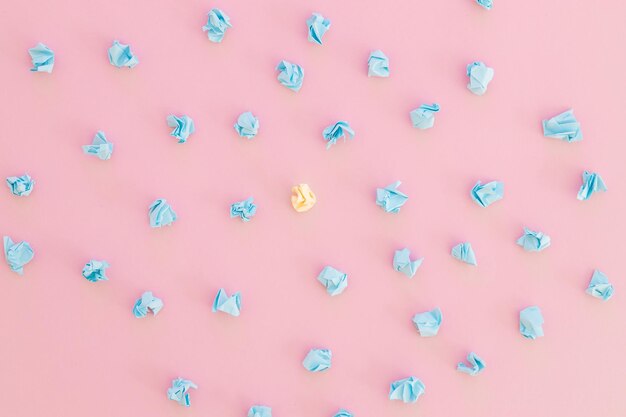 Top view of unique crumpled yellow paper among blue on pink background New idea In search