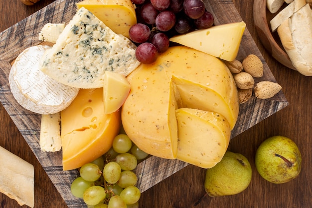 Top view variety of cheese with fruits