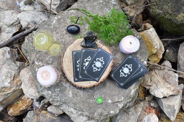 Top view of various objects for rituals and divination on a large stone against the background of a mountain river