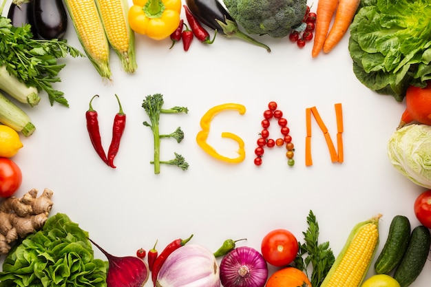 Top view vegan lettering made out of vegetables on white background