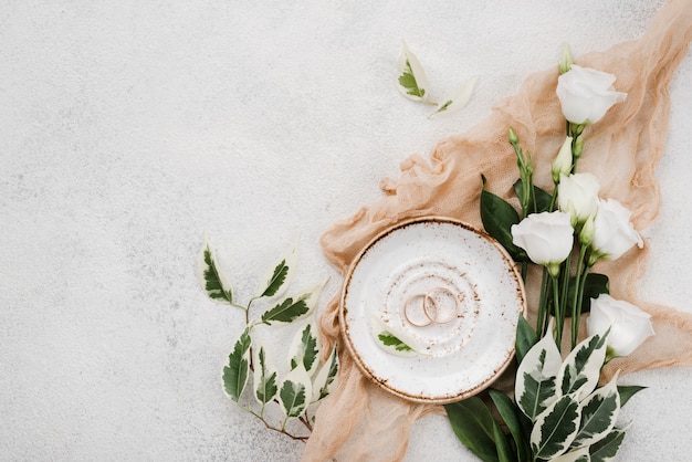 Photo top view wedding rings and flowers with copy space