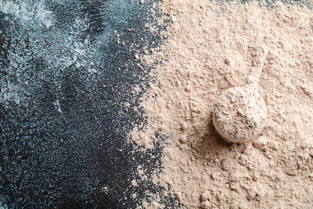 Top view whey protein scoop on dark background, copy space