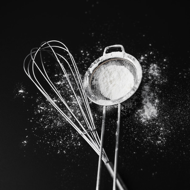 Top view whisk with sugar powder on the table