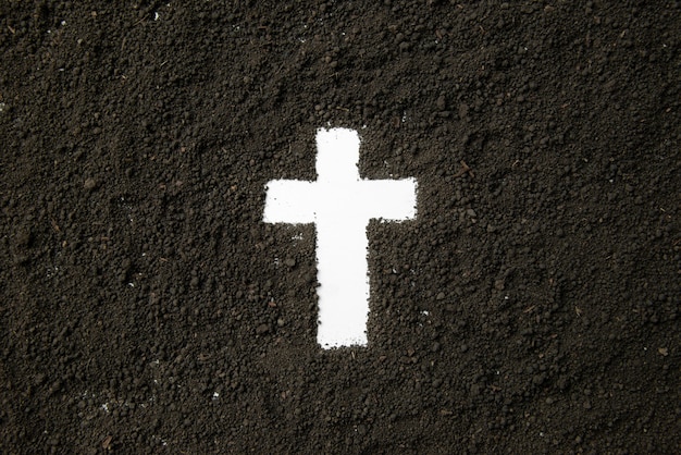 Top view of white cross shape with dark soil