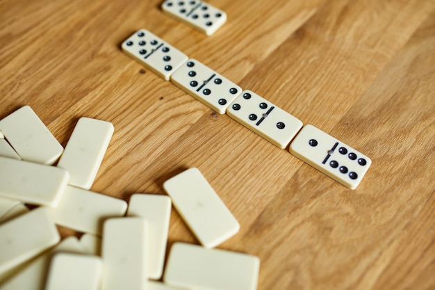 Top view of white domino games on wooden table background with copy space board game concept