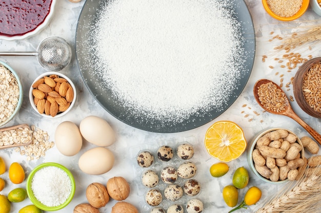 top view white flour around eggs seeds nuts and jelly. color food pie cake jam bake dough egg