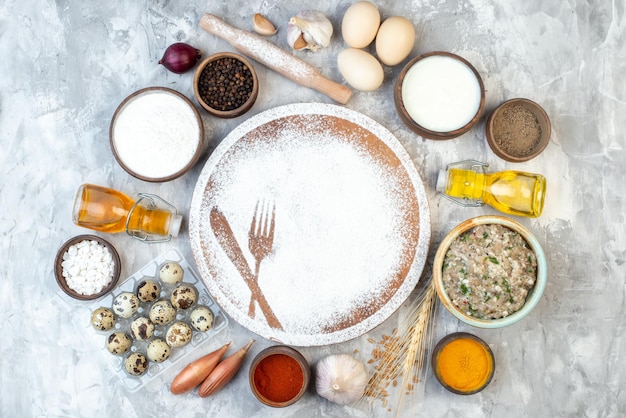 Top view white flour in fork and spoon shape with seasonings and eggs on white background dough pie color salad food cake