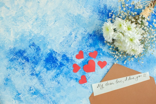 top view white flowers love letter little red hearts on blue background free space