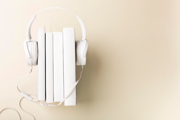 Top view of white headphones and notebooks on background with copy space Flat lay