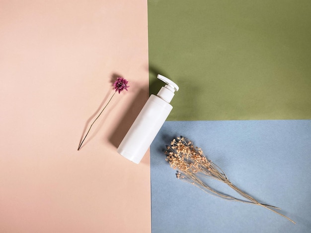 Top view of white plastic bottle and dried plants