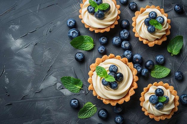 Photo top view on wholegrain blueberry tarts with vanilla cream on dark