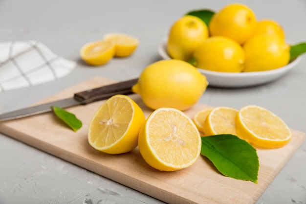 Top view with copy space for fresh and ripe lemons on cutting board Healthy food background Elegant background of lemon and lemon slices with squeezer colored background