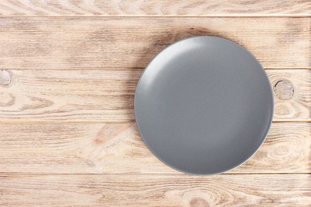 Photo top view with copy space gray empty round plate on wooden background