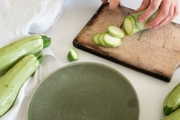 Top view of a woman cutting fresh ripe garden zucchini