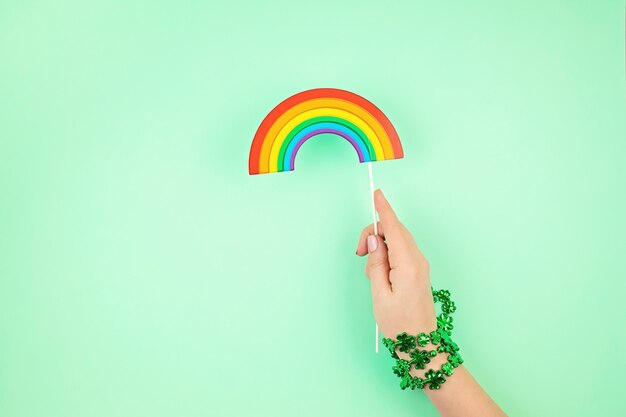 Top view over woman hand holding Saint Patrick day symbols in traditional colors.