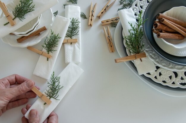 Photo top view of woman hands preparing and arranging the table for winter holidays. winter decoration, diy