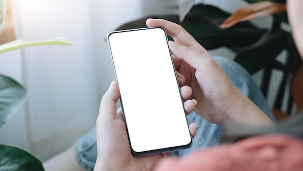 Top view Woman sitting and holding blank screen mock up mobile phone