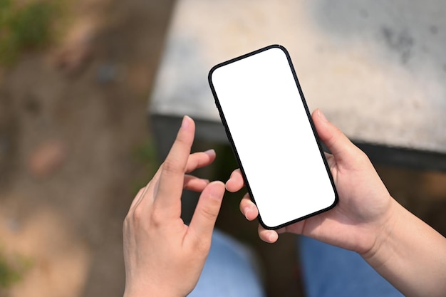 Top view of a woman using her phone in the park or garden phone white screen mockup